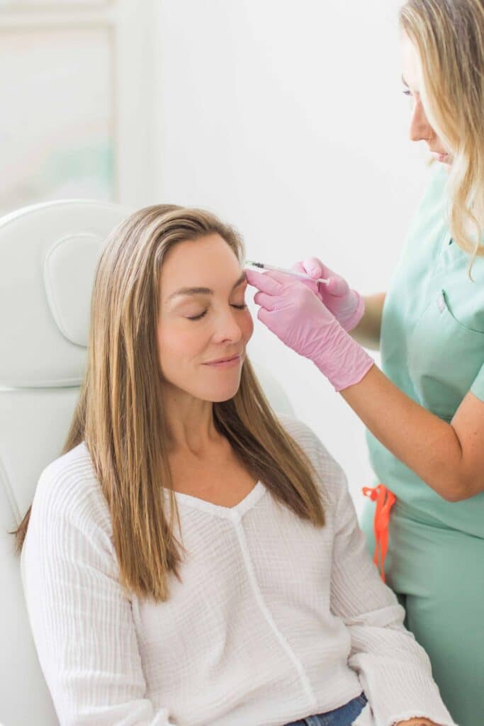 Calm dreamy aesthetic clinic customer sitting in chair during mesotherapy procedure performed by dermatologist. Female patient getting cheek Botox filler injection | San Carlos IV Bar in San Carlos, CA