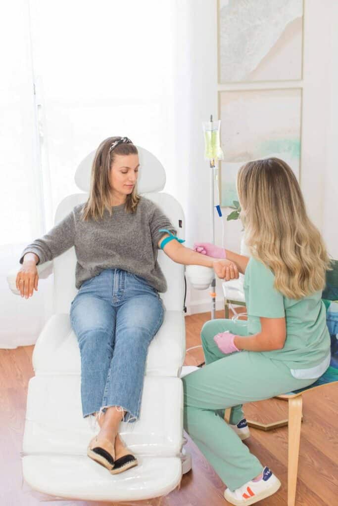 Doctor attaching intravenous drip on lady hand. beautiful woman in chair and receiving IV infusion | San Carlos IV Bar in San Carlos, CA