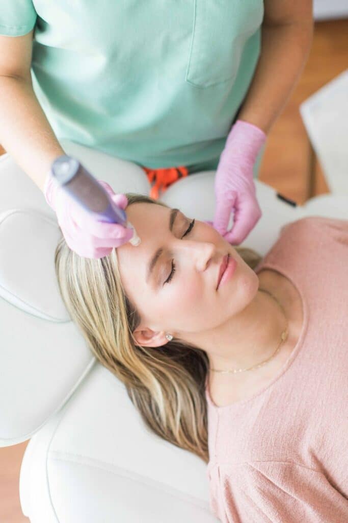 Close up portrait of blonde woman with cosmetologist hands giving SkinPen Microneedling | San Carlos IV Bar in San Carlos, CA