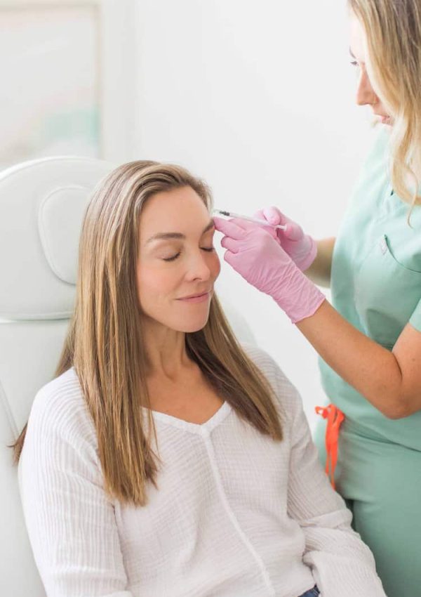 Calm dreamy aesthetic clinic customer sitting in chair during mesotherapy procedure performed by dermatologist. Female patient getting cheek Botox filler injection | San Carlos IV Bar in San Carlos, CA