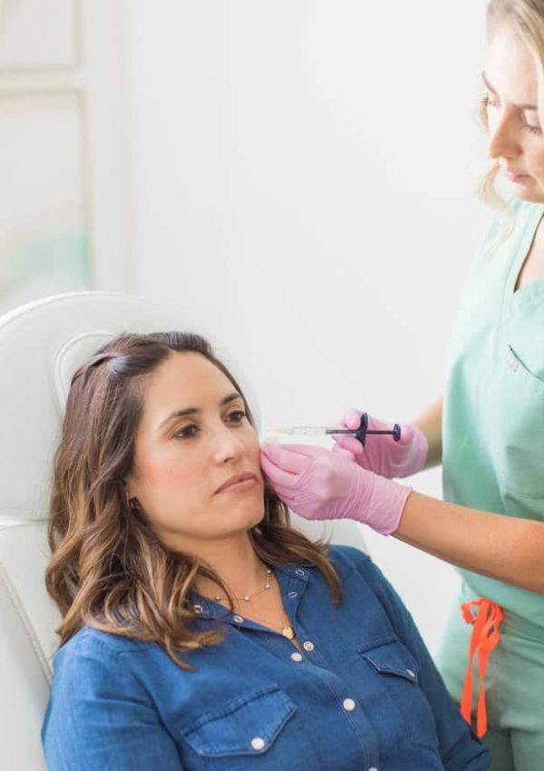 Calm dreamy aesthetic clinic customer sitting in chair during mesotherapy procedure performed by dermatologist. Female patient getting cheek dermal filler injection | San Carlos IV Bar in San Carlos, CA